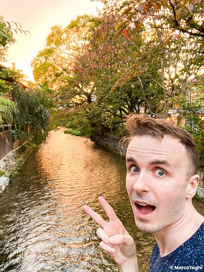 Marco Togni sorride davanti al fiume Shirakawa a Kyoto al tramonto.