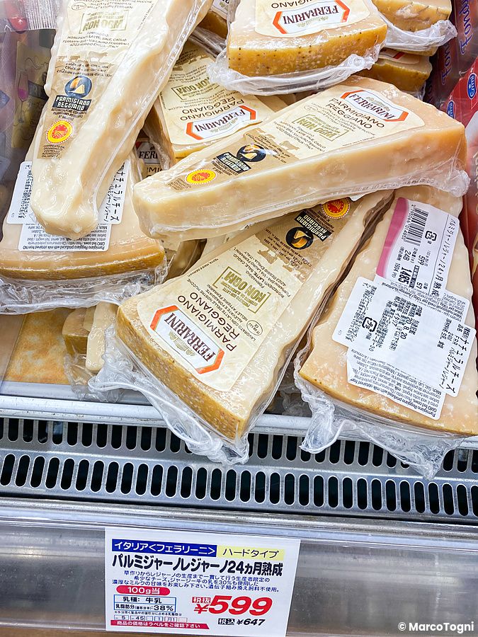 Confezioni sottovuoto di formaggio Parmigiano Reggiano Ferrarini esposte nel banco frigo da Seijo Ishii.