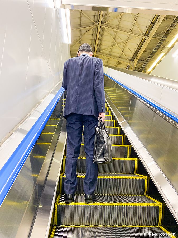 uomo in abito formale su scala mobile in Giappone