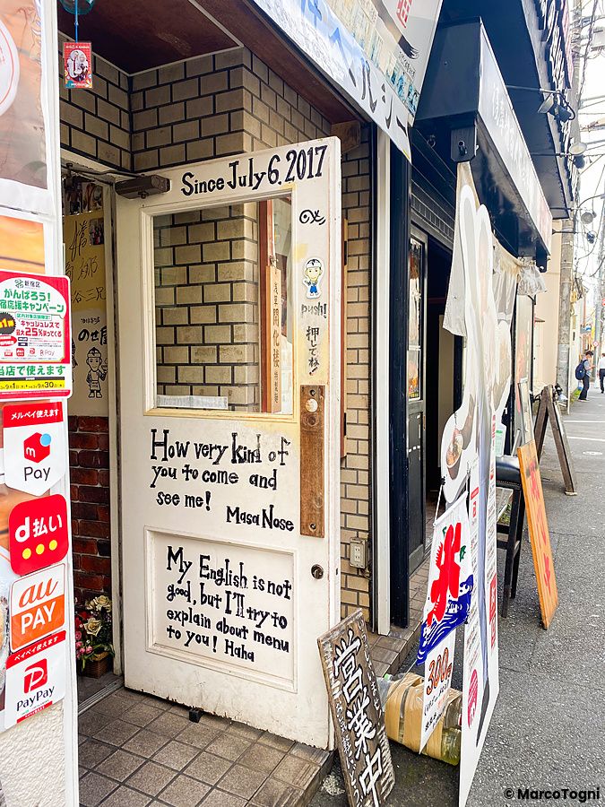 Porta di un ristorante in Giappone con invito per chi parla inglese.