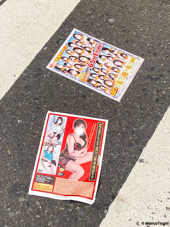 Volantini di locali per adulti su una strada a Shinjuku.