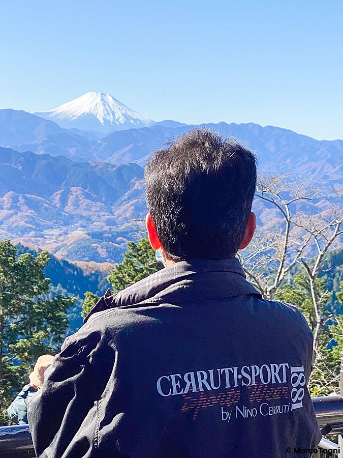 una persona osserva il monte Fuji dalla cima del monte Takao.