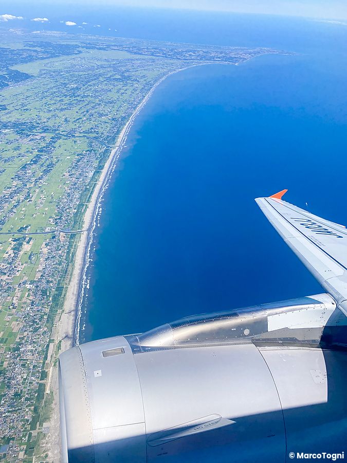 Vista aerea della costa giapponese con motore d'aereo visibile.