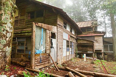 Struttura abbandonata in legno sul Monte Mitake, avvolta dalla foschia.