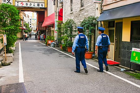 Due agenti di polizia a Tokyo pattugliano a piedi una strada nel quartiere di Asakusa.