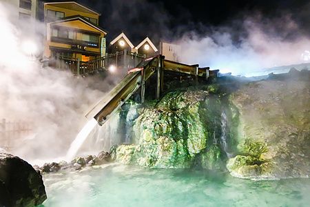 Yubatake a Kusatsu Onsen di notte con vapore e acqua termale