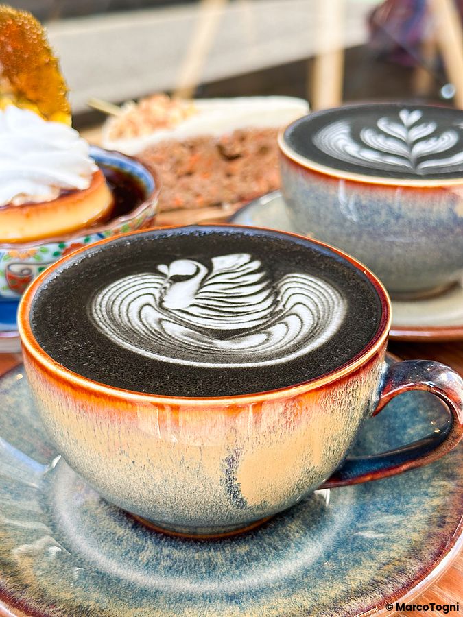 Due tazze di caffè con latte art a forma di cigno e un dessert presso il Liwei Coffee Stand, Tokyo.