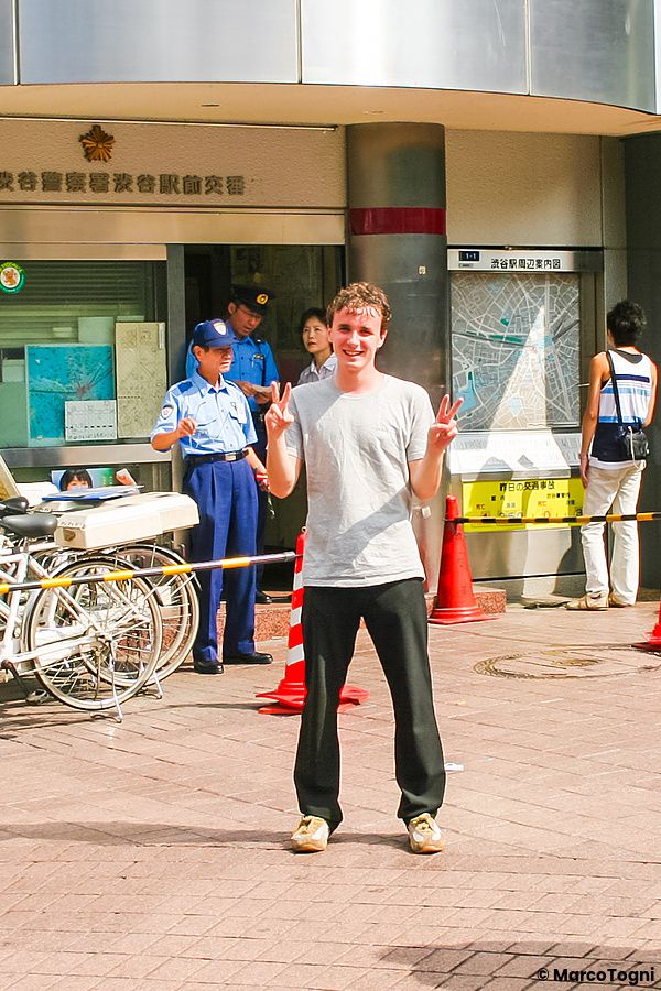 Marco Togni fa il segno di vittoria davanti al posto di polizia Shibuya Ekimae a Shibuya.