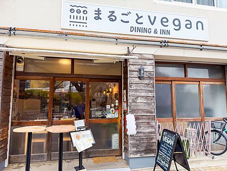 L'ingresso del ristorante Marugoto Vegan Dining ad Asakusa con insegna, vetrate in legno e cavalletto informativo.