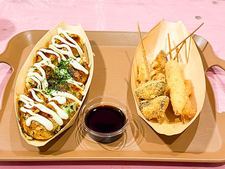 Vassoio di plastica marrone con takoyaki vegani e spiedini kushiage gluten free serviti presso il ristorante OKO.