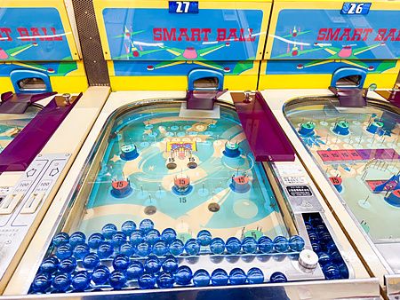 Macchine da gioco vintage in stile flipper con biglie blu presso la sala giochi Smartball New Star a Osaka.