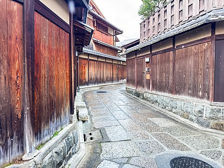 La strada Ishibei Koji a Kyoto è un vicolo stretto con pavimentazione in pietra e pareti di legno scuro ai lati.