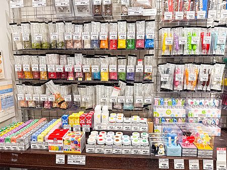 Scaffali pieni di decorazioni per dolci e coloranti alimentari in vendita presso il negozio Tomizawa Shoten a Machida.