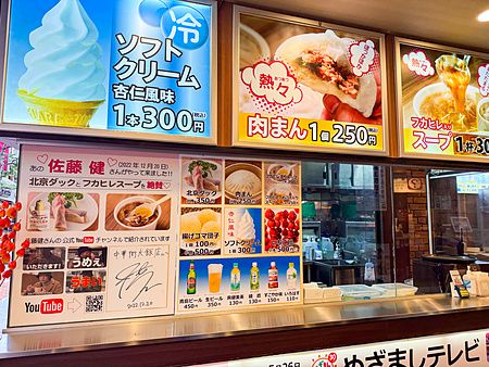 Vetrina esterna con menu illustrati di cibi d'asporto presso il ristorante Chukagai Daihanten a Yokohama.