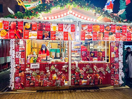 Una bancarella di cibo decorata a tema natalizio al Yokohama Red Brick Christmas Market, con numerosi menù esposti.
