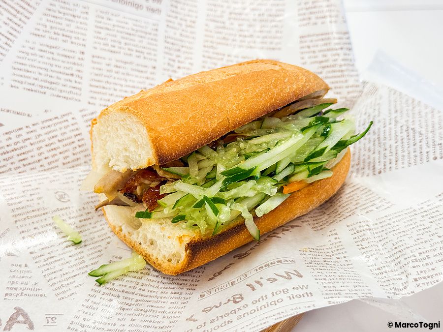 Un bánh mì farcito con cetrioli e carne servito su carta alimentare al Café Giang a Yokohama.