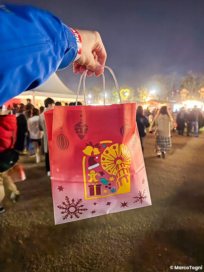 Una mano tiene una busta rossa decorata con motivi natalizi al Tokyo Christmas Market presso il Meiji Jingu Gaien.