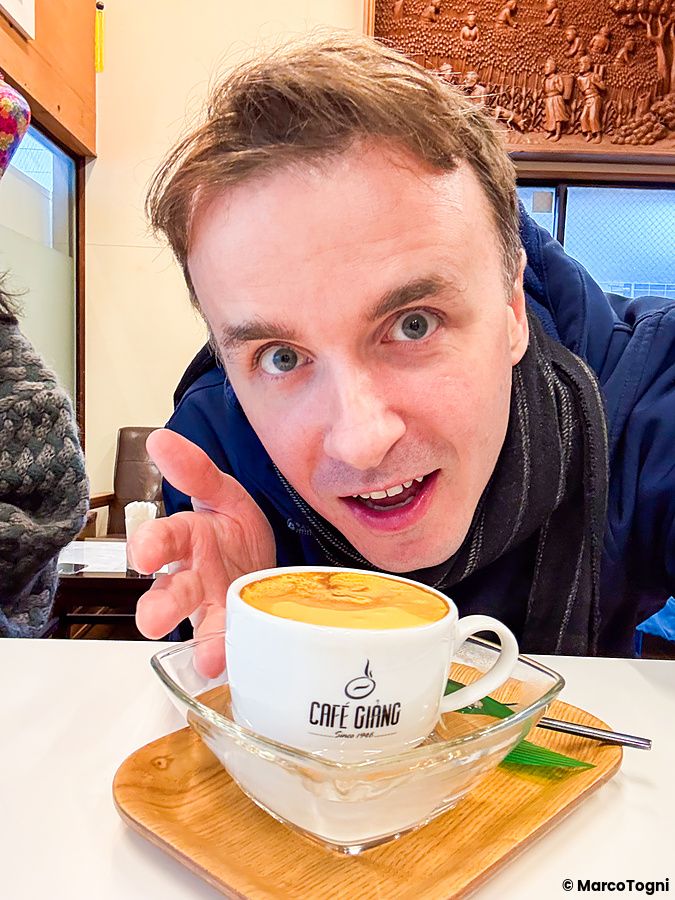 Marco Togni mostra con entusiasmo una tazza di caffè all'uovo al Café Giang a Yokohama.