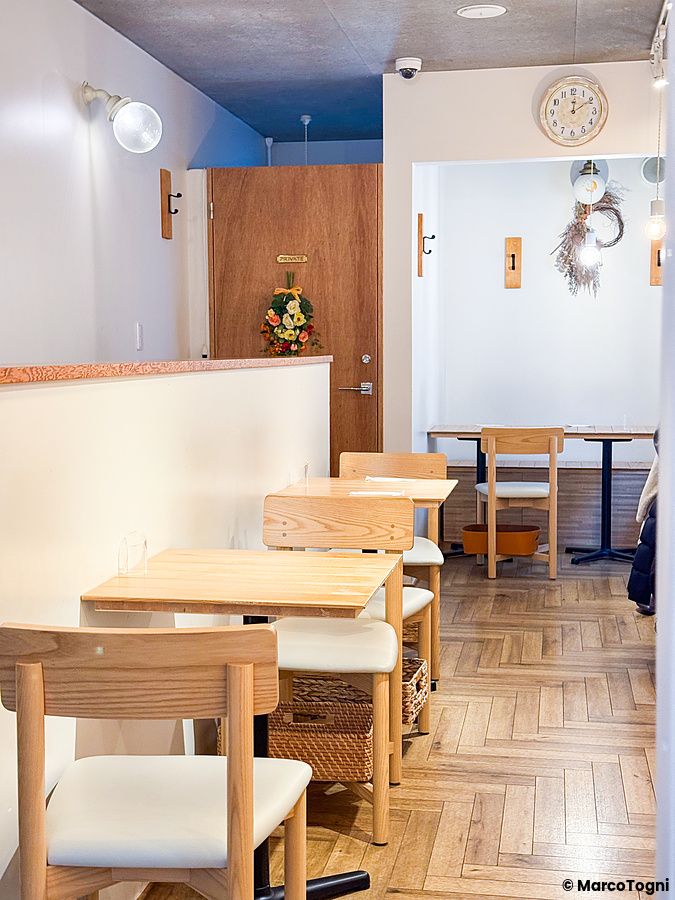 L'interno a Chaka mostra tavoli in legno e sedie bianche disposti in un ambiente luminoso a Kita-Senju, Tokyo.