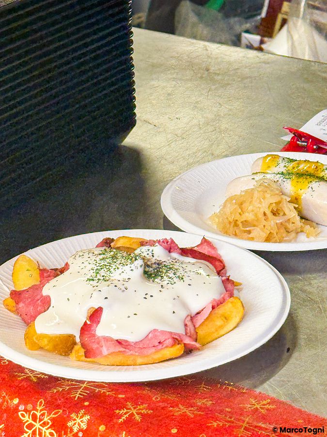 Piatti con carne arrosto, patate, wurstel e crauti serviti allo Yokohama Red Brick Christmas Market.