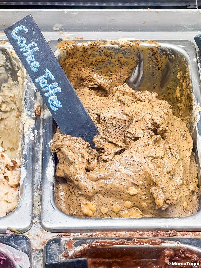 Una vaschetta di gelato vegano gusto Coffee Toffee con un cartellino identificativo presso la gelateria Coconut Glens.