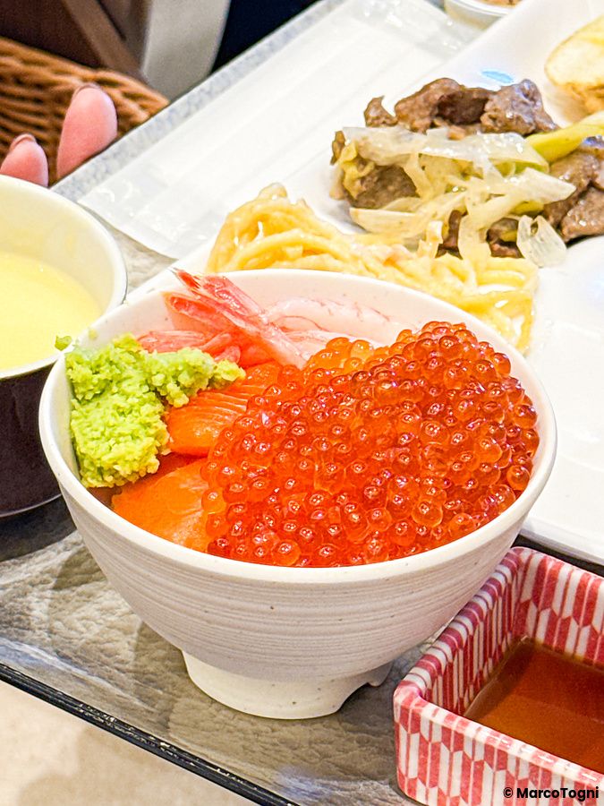 Ciotola di riso con uova di salmone e salmone a fette servita per colazione a La Vista Tokyo Bay.