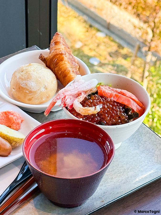 Una colazione presso La Vista Tokyo Bay che include una ciotola di riso con uova di salmone, zuppa di miso e pane.