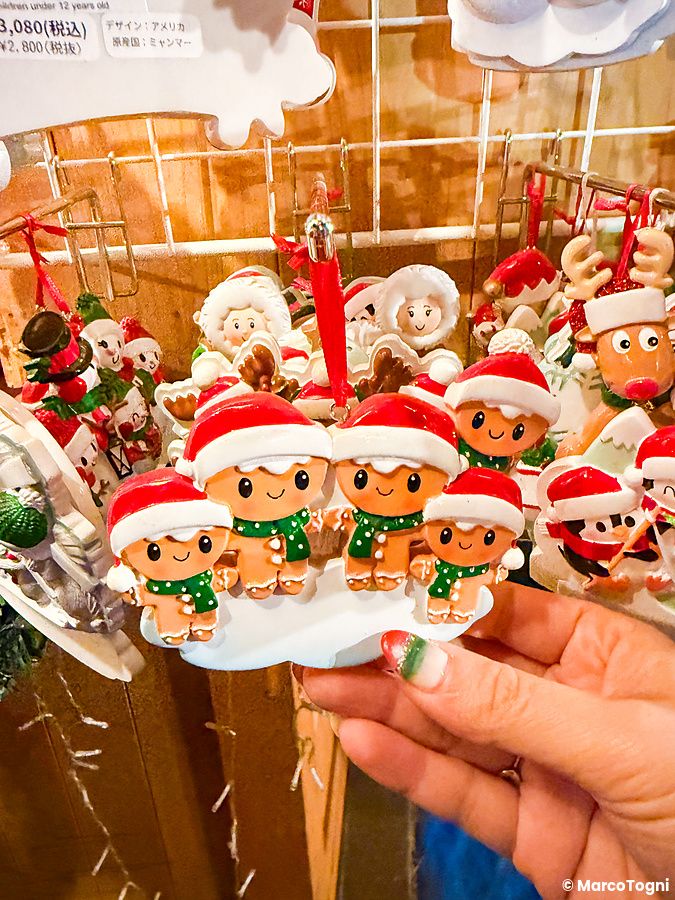 Una mano tiene una decorazione natalizia con quattro omini di pan di zenzero al Tokyo Christmas Market.