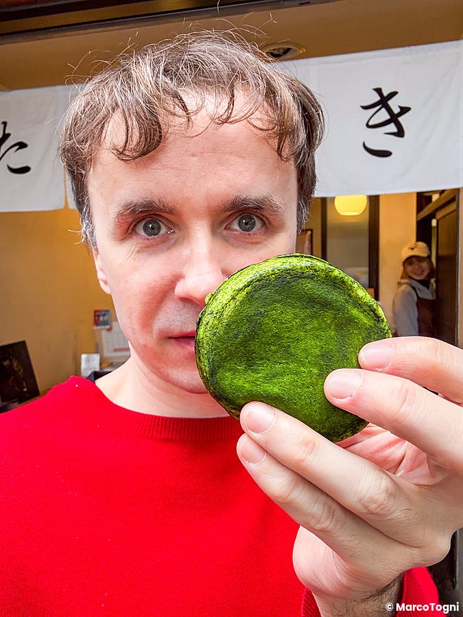 Marco Togni tiene in mano un dolcetto con matcha davanti al negozio Hakata Hiiragi Taiyaki a Fukuoka.