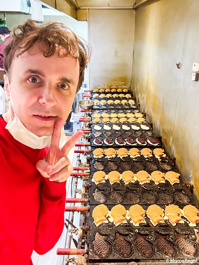 Marco Togni prepara i taiyaki su lunghe piastre metalliche all'interno del negozio Hakata Hiiragi Taiyaki di Fukuoka.