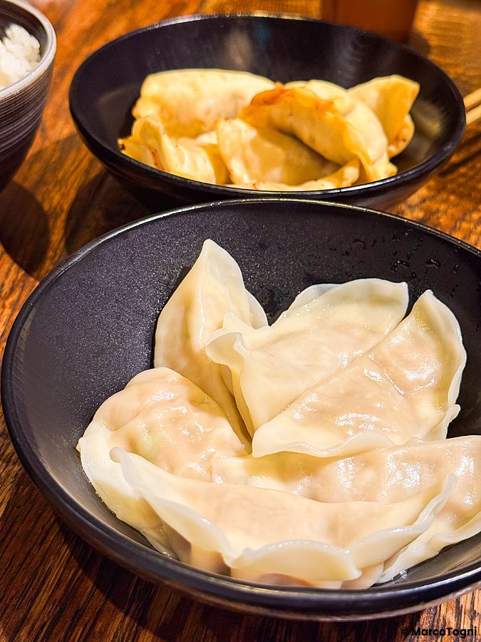 Gyoza al vapore serviti in una ciotola nera presso il ristorante Gyoza no Fukuho a Tokyo.
