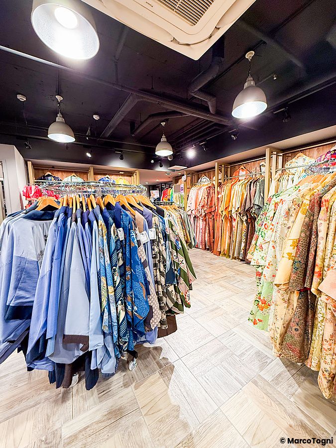 Interno del negozio Chicago Harajuku a Tokyo con file di kimono e yukata appesi su scaffali.