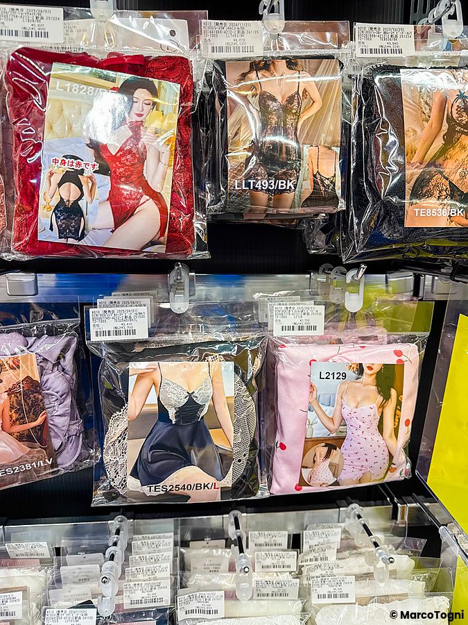 Lingerie in vendita appesa su ganci presso un sexy shop in Giappone con confezioni che ritraggono una persona.