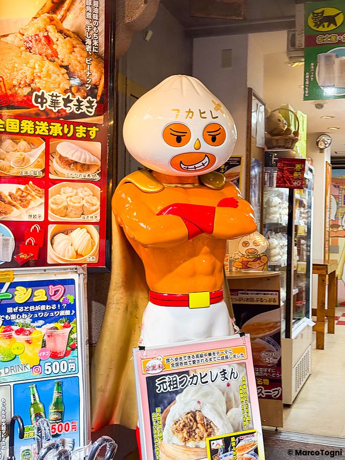 La mascotte all'ingresso a Koseiwa a Yokohama è una statua di un personaggio con la testa a forma di panino al vapore.