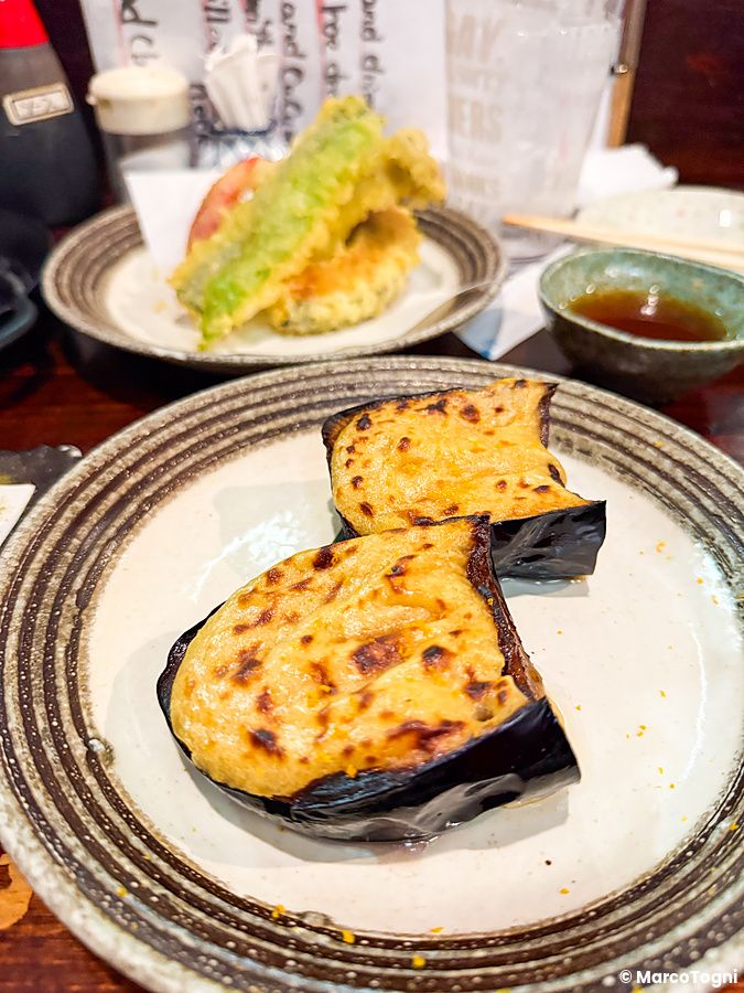Melanzane con formaggio nel ristorante Gion Yuki a Kyoto, con tempura di verdure sullo sfondo.