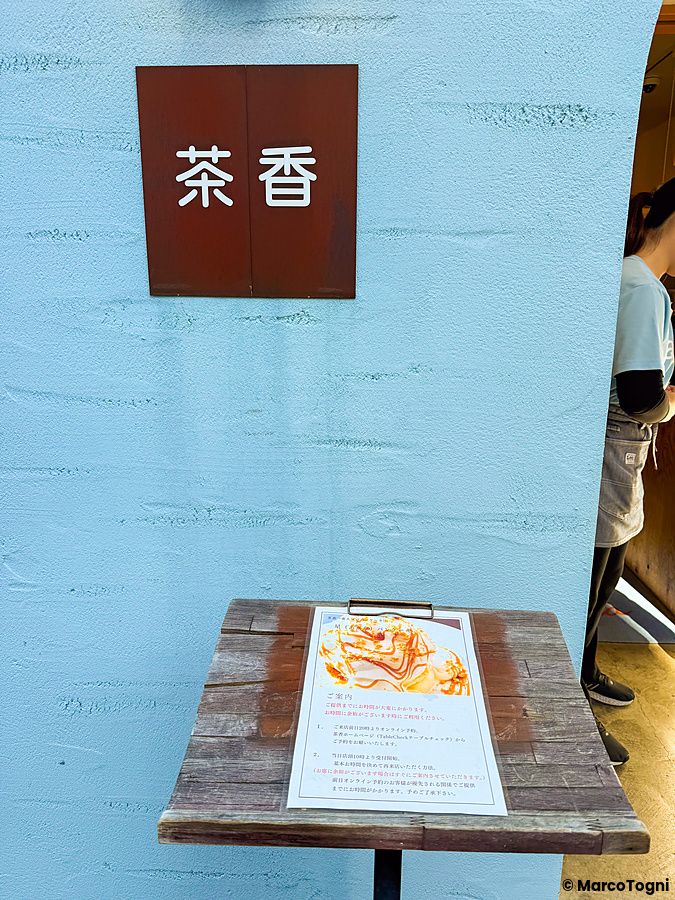 Un leggio in legno con il menu esposto all'esterno del ristorante Chaka a Kita-Senju, Tokyo.
