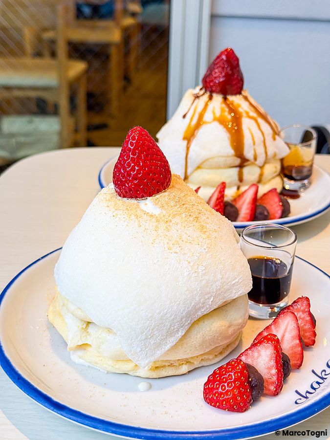 Due pancake con mochi e fragole serviti su piatti bianchi con bordo blu presso il ristorante Chaka a Kita-Senju.