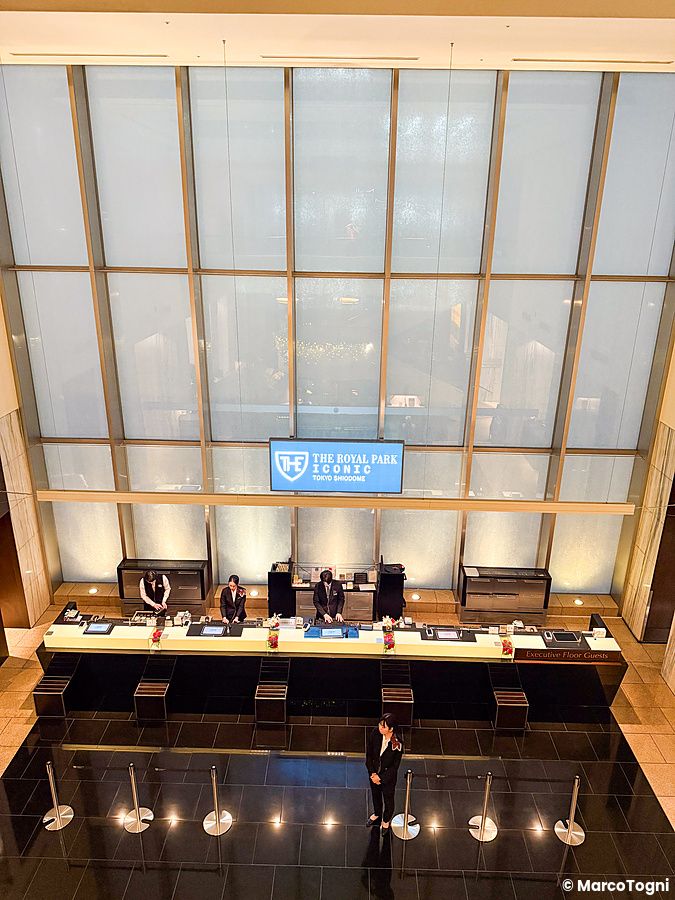 La reception a The Royal Park Hotel Iconic Tokyo Shiodome con personale in divisa dietro il banco principale.