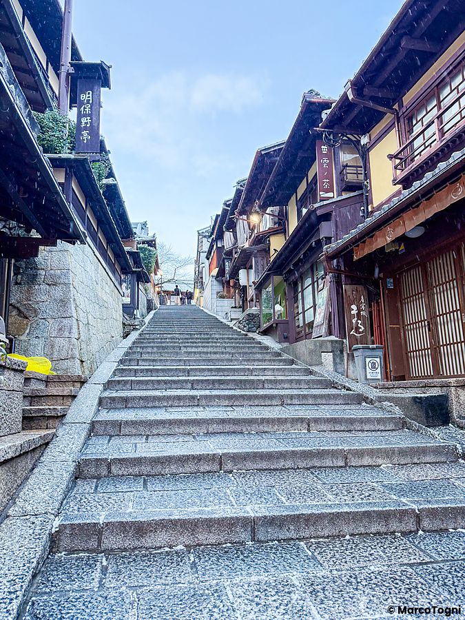 Veduta dal basso della scalinata in pietra della strada Sannenzaka a Kyoto durante una giornata di neve in inverno.
