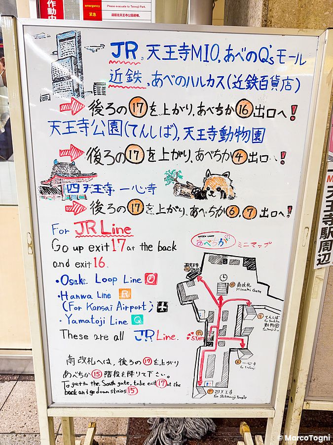 Mappa informativa disegnata su una lavagna bianca in un corridoio all'interno di una stazione ad Osaka.