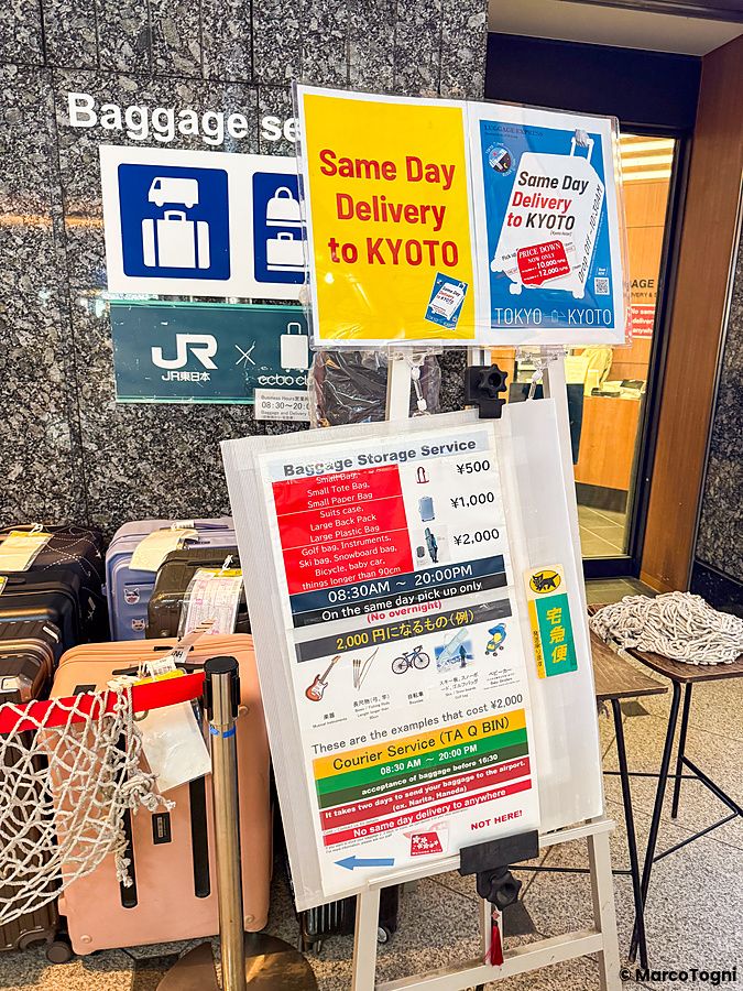 Cartelli informativi relativi al servizio di deposito e consegna bagagli situati nella stazione di Tokyo.