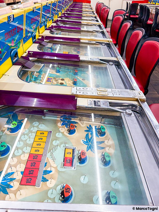 Una fila di macchine da gioco vintage Smart Ball con decorazioni tropicali all'interno della sala Smartball New Star.