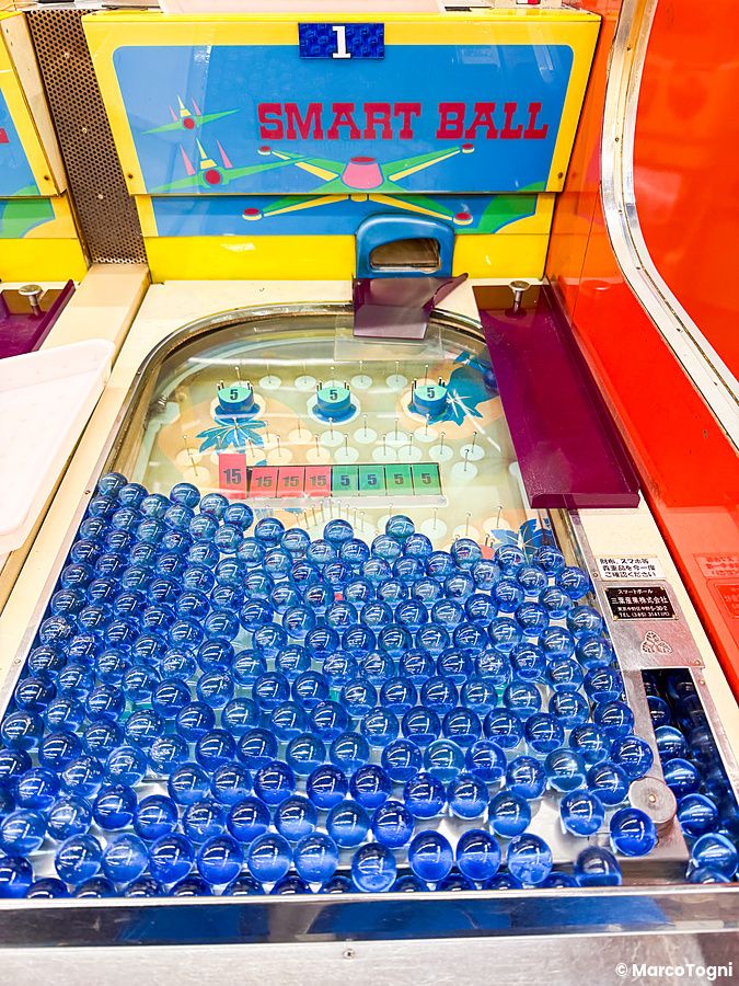 Dettaglio di una macchina da gioco vintage Smart Ball con sfere blu presso la sala giochi Smartball New Star a Osaka.