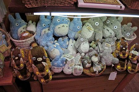 Ripiano di un negozio dello Studio Ghibli in Giappone ricolmo di peluche di Totoro di varie dimensioni.