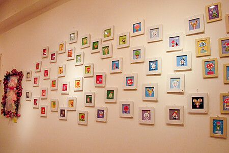 Parete decorata con piccole cornici colorate all'interno di Junie Moon a Daikanyama.