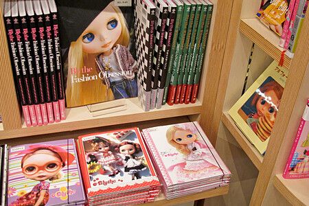 Scaffale con libri su bambole Blythe nel negozio Junie Moon.