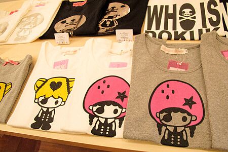 Magliette colorate con disegni stilizzati esposte in un negozio Junie Moon.