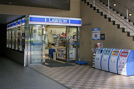 Ingresso di un negozio Lawson in Giappone con distributori automatici accanto.