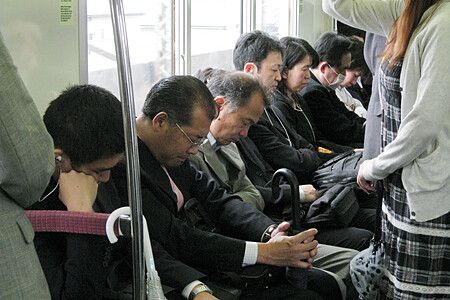 Pendolari giapponesi che dormono su un treno.