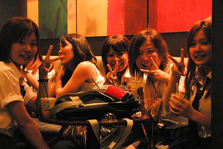 Ragazze in divisa scolastica sedute al bar in Giappone.